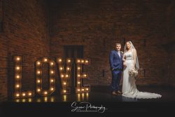 donington park farmhouse wedding photography bride groom on stage with love letters